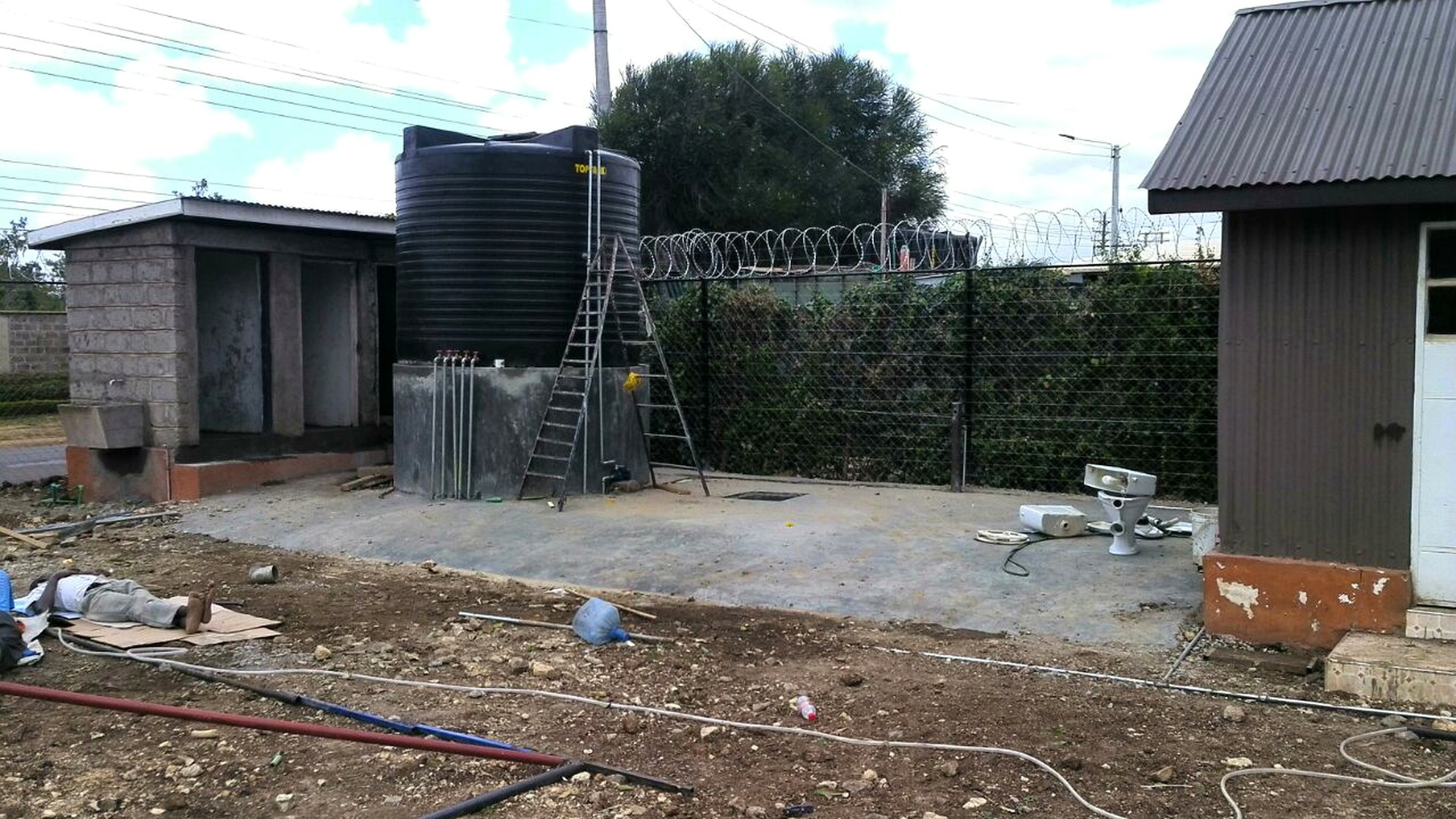 Water tank and pump house construction site with infrastructure setup