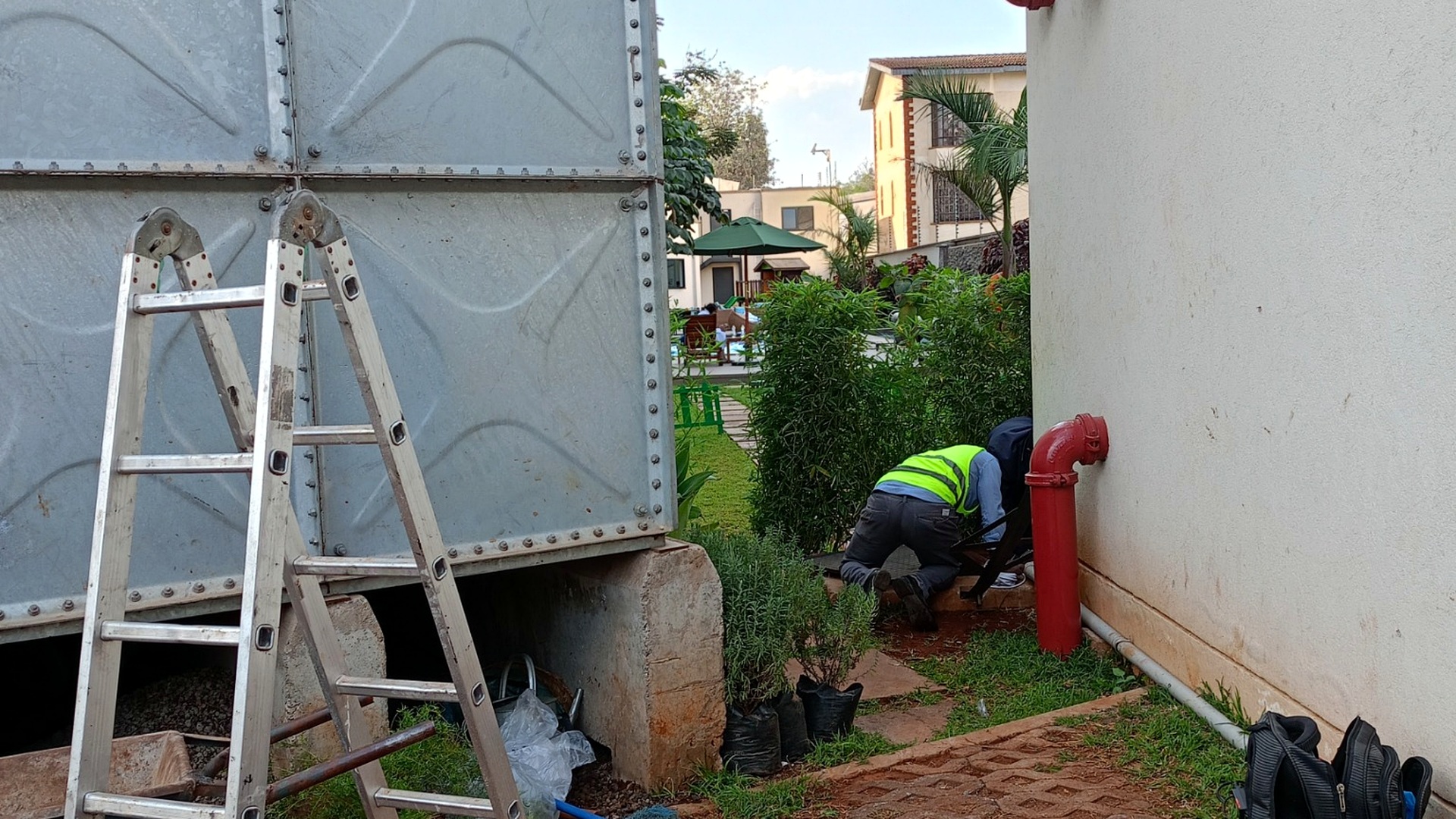 Technician inspecting water tank plumbing at Somerset property