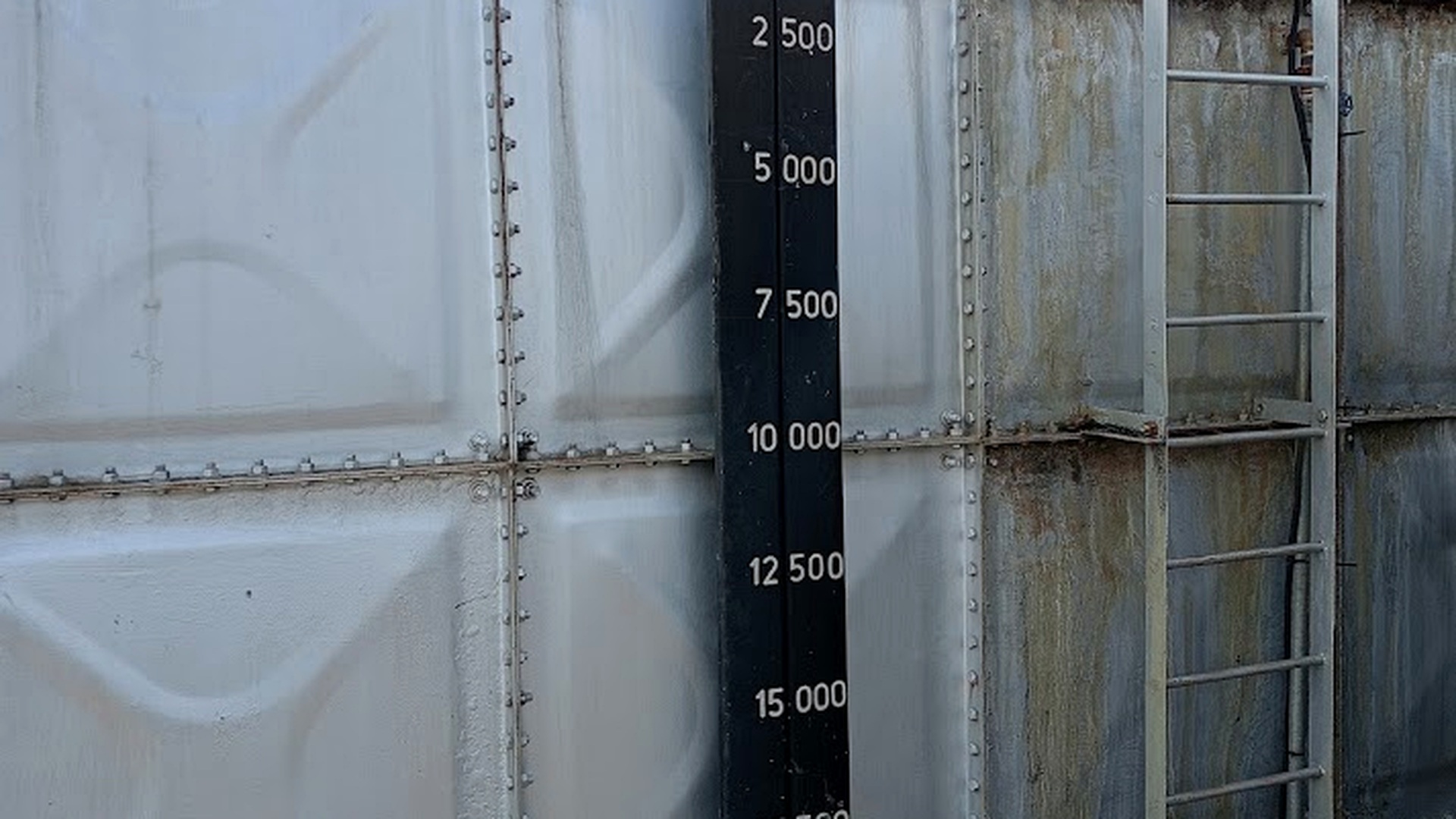 Industrial water tank with level gauge markings close-up